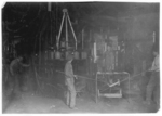 Lewis Hine child labor: O'Neill Bottle Machine, Mannington Glass Wks., Mannington, W. Va. Blows bottles by compressed air. Managers do not believe in using small boys or girls and do not do it: large boys are paid same rate as small boys would receive, $1 a day. Location: Mannington, West Virginia.